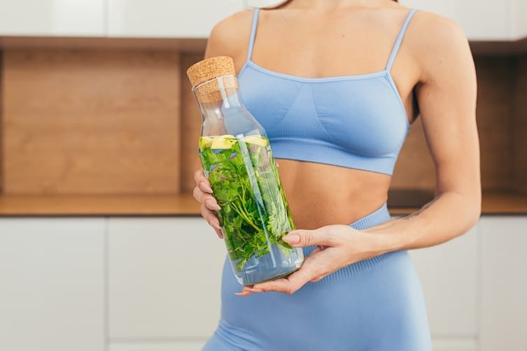 mujer con botella de agua y limon con menta